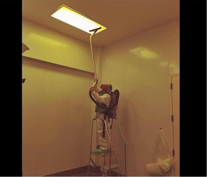 SERVPRO technician hepa vacuuming a ceiling